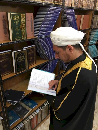 رجل دين يطلع على احد الكتب