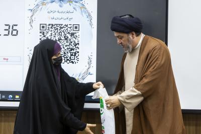 السيد جعفر المروج يكرم إحدى الطالبات المرتديات للعباءة الاسلامية