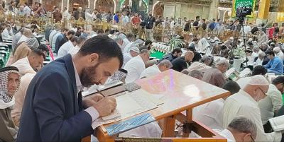 خلال الختمات القرآنية.. خطاط في المجمع العلمي يخط الآيات أثناء التلاوة المباشرة