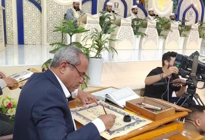 خلال الختمات القرآنية.. خطاط في المجمع العلمي يخط الآيات أثناء التلاوة المباشرة