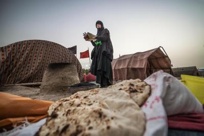منذ أكثر من 18 عامًا والحاجّة أمّ ماجد تبني تنورها خلف المواكب في شارع حمدان في البصرة. لا تتخلّف عن الموعد ولا عن خدمة الزوّار السائرين نحو الإمام الحسين (عليه السلام). على الرغم من أنّها لا تمتلك موكبًا إلّا أنّ العديد من المواكب تعتمد عليها في توفير الخبز الطازج. وتضيف قائلة: لا أطمع في شيء سوى رضى الله و رضى مولاتي السيدة فاطمة الزهراء (عليها السلام).