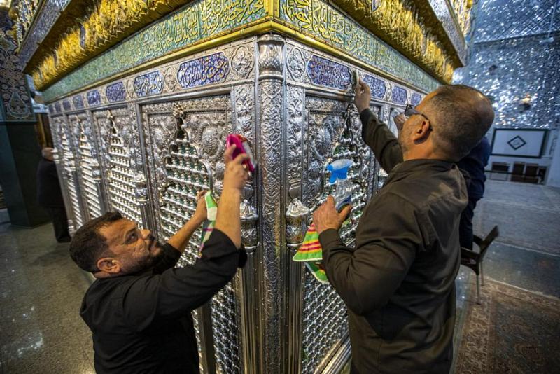خَدَمَةُ أبي الفضل العبّاس (عليه السلام) يعطّرون شبّاك مرقد أخته العقيلة