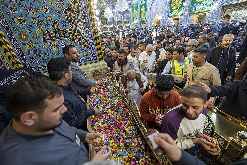 ملاكات العتبة العباسية المقدسة تستقبل الزائرين بالورد والحلوى بمناسبة زيارة النصف من شعبان