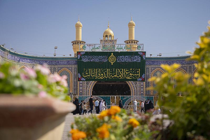 تعليق اللافتة الرئيسة لأسبوع الإمامة الدولي الثالث في باب قبلة مرقد أبي الفضل العباس (عليه السلام)