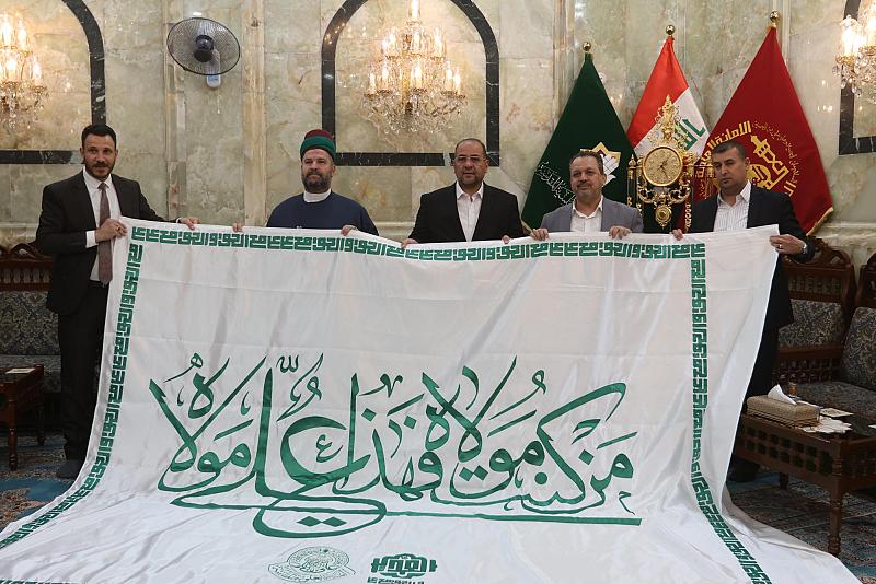 تزامناً مع قرب عيد الغدير الأغرّ.. العتبة العلوية تُهدي العتبةَ العبّاسية راية الولاية