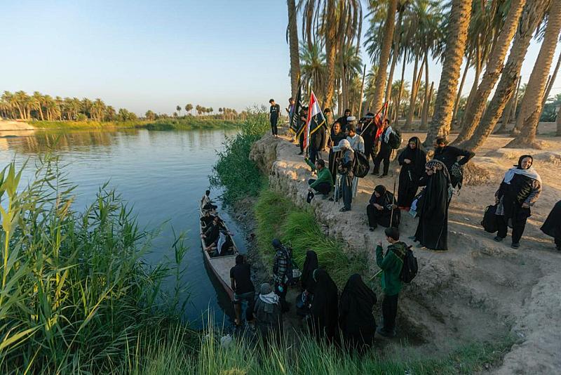 (قوارب في خدمة الزائرين) على ضفاف نهر الفرات في منطقة القزوينية التابعة لقضاء الكوفة، يجهز الأهالي قوارب لنقل الزائرين من الضفة الأخرى إلى منازلهم ليتبركوا بخدمتهم، يستمر عملهم منذ الصباح حتى وقت متأخر من الليل.