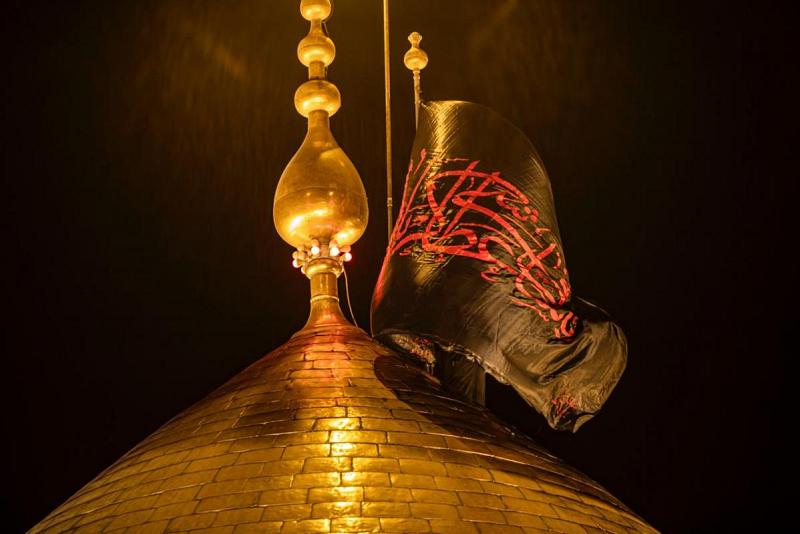 استبدالُ رايتَيْ قبّتَيْ حرم الإمام الحسين وأخيه أبي الفضل العبّاس (عليهما السلام) إلى رايات الحزن والحداد