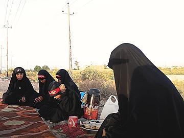 أم طه من أهالي ذي قار، تقف مع بناتها في موكب بسيط على جانب الطريق ليقدمن الخدمة للزائرين، هيَ تظن أنَّ ما تقدمه قليل إزاء صدق نيتها، ومحبتها للإمام الحسين (عليه السلام).